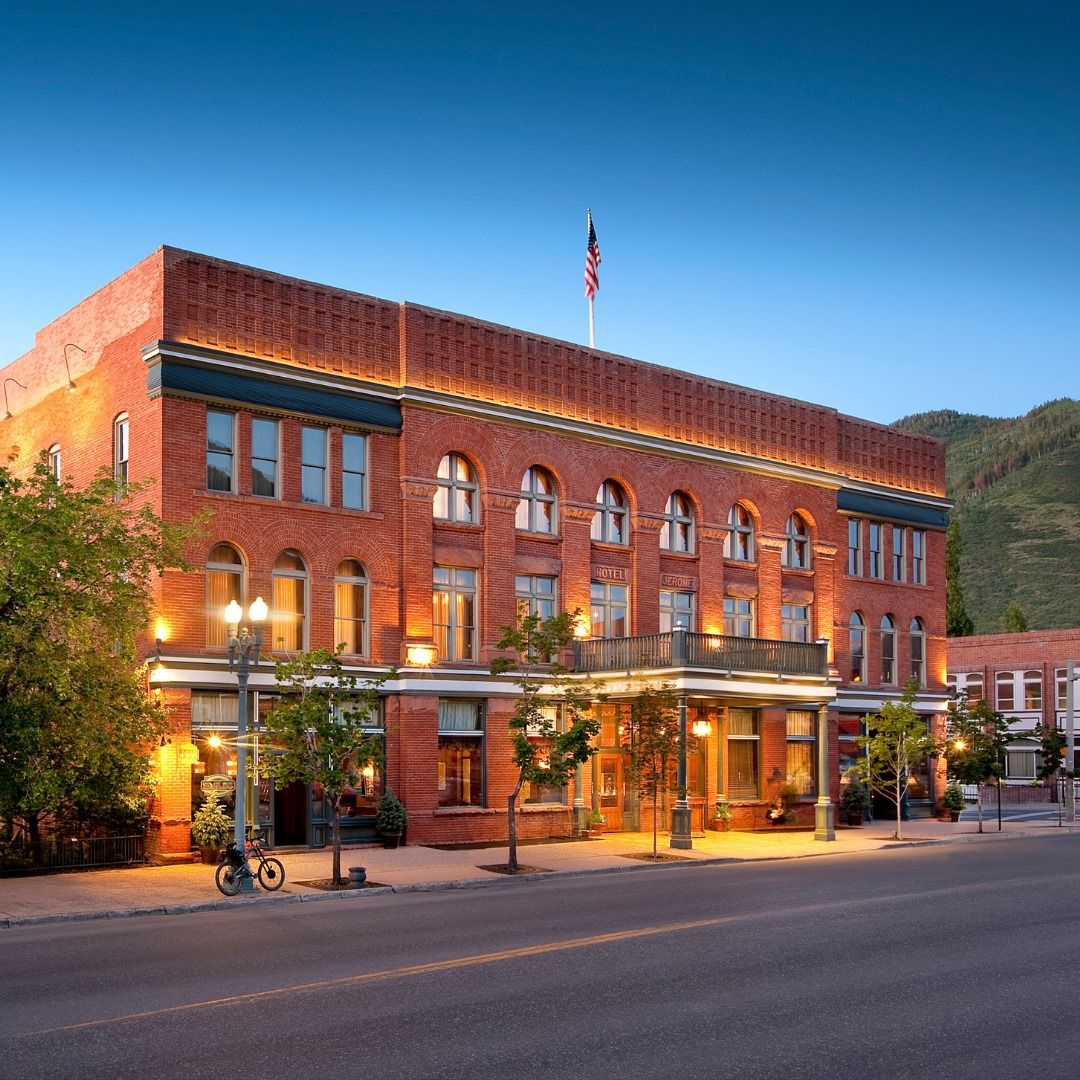 The historic red-brick Hotel Jerome at dusk with the American flag flying